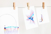 Aesthetic chromatography art on white papers hanging on a rope