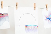 Aesthetic chromatography art on white papers hanging on a rope