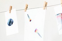 Aesthetic chromatography art on white papers hanging on a rope