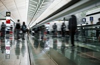 People on a moving walkway in a passenger terminal at the airport
