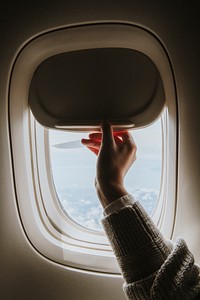 Woman opening a window shade