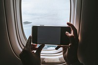 Woman taking a picture from the window seat on an airplane