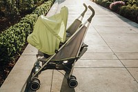 Green baby carriage on a sidewalk