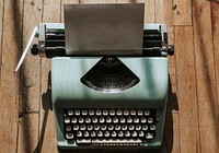 Retro mint typewriter with a blank white paper