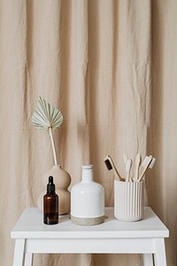 Brown dropper bottle and bamboo toothbrushes on a white table