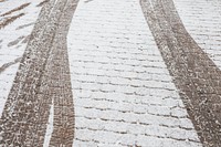 Skid marks on a an icy cobblestone road background