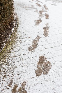 Footsteps on a snowy cobblestone road background