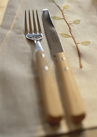 Free knife and fork on a large brown serviette photo, public domain CC0 image.