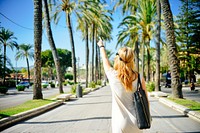 Free woman walking on road with palm tree image, public domain CC0 photo.