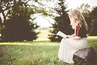 Free young woman reading a book outside on a rock photo, public domain book CC0 image.