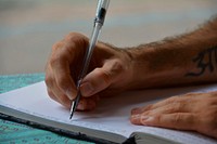 Free close up of a hand writing notes in a journal photo, public domain CC0 image.