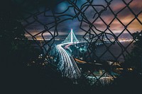 Free road in motion at night through a broken wire fence image, public domain CC0 photo.