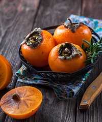 Free sliced ripe persimmon fruit on wooden table photo, public domain yyy CC0 image.