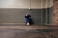 Free person crying and sitting against the wall public domain CC0 photo.