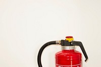 Free fire extinguisher on white wall photo, public domain emergency CC0 image.