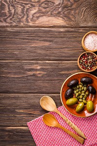 Free olives and herbs in bowls on wooden table photo, public domain food CC0 image.