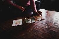 Free person looking at drawings on table photo, public domain machine CC0 image.