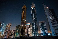 Free man standing before buildings image, public domain cityscape CC0 photo.