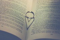 Free heart shadow from wedding ring on book photo, public domain CC0 image.