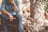 Free man sitting in woodpile holding a book image, public domain CC0 photo.