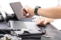 Free person checking watch on working table photo, public domain CC0 image.