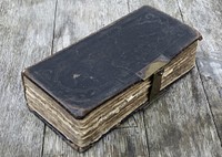 Free old closed book on wooden table photo, public domain CC0 image.