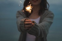 Free person holding sparkler image, public domain celebration CC0 photo.