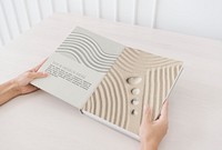 Wellness book mockup psd with zen sand and stones on the pages