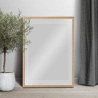 Picture frame mockup psd leaning in minimal living room home decor interior