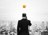 Emoji on a businessman talking on his phone overlooking the city