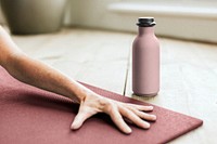 Pink bottle near person doing yoga