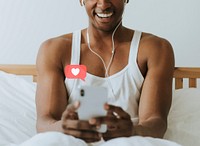 Cheerful black man texting on his phone