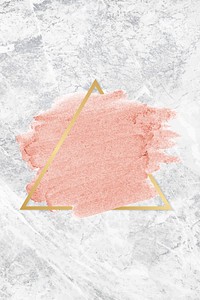 Pastel pink paint with a gold triangle frame on a grunge concrete background