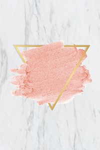 Pastel pink paint with a gold triangle frame on a white marble background
