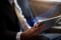 Businessman using a digital tablet in a car