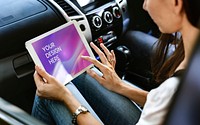 Woman using a digital tablet in a car