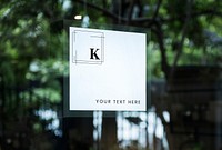 Square white shop sign mockup on a window