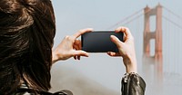 Woman taking a photograph of the Golden Gate Bridge, San Francisco