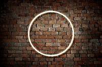 Neon fist in a round frame on a brick wall