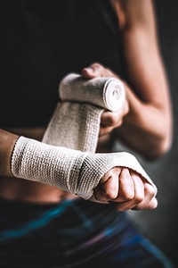 Female boxer putting a strap on her hand