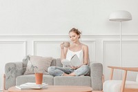 Woman reading while having tea in minimal living room