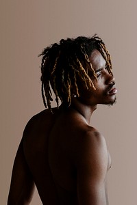 Black man posing by a beige background