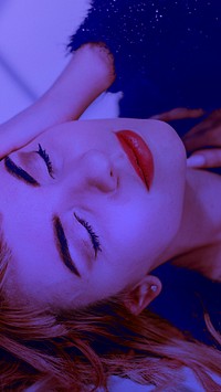 Brown hair woman in a black fluffy sweater lying on a floor