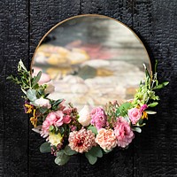Golden floral mirror on a black wall