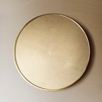 Gold framed mirror on a brown wall