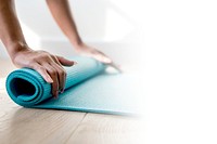 Woman rolling up a yoga mat during coronavirus quarantine