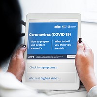 Woman reading coronavirus information from a tablet mockup with editorial graphic from <a href="https://www.coronavirus.gov/">https://www.coronavirus.gov/</a> accessed on April 8th 2020. BANGKOK, THAILAND - JANUARY 19, 2018