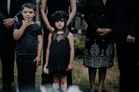 Sad grandkids standing by the grave