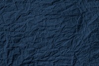 Crumpled dark blue paper textured background