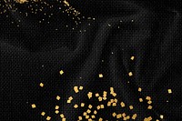 Gold glitter on a black fabric textured background